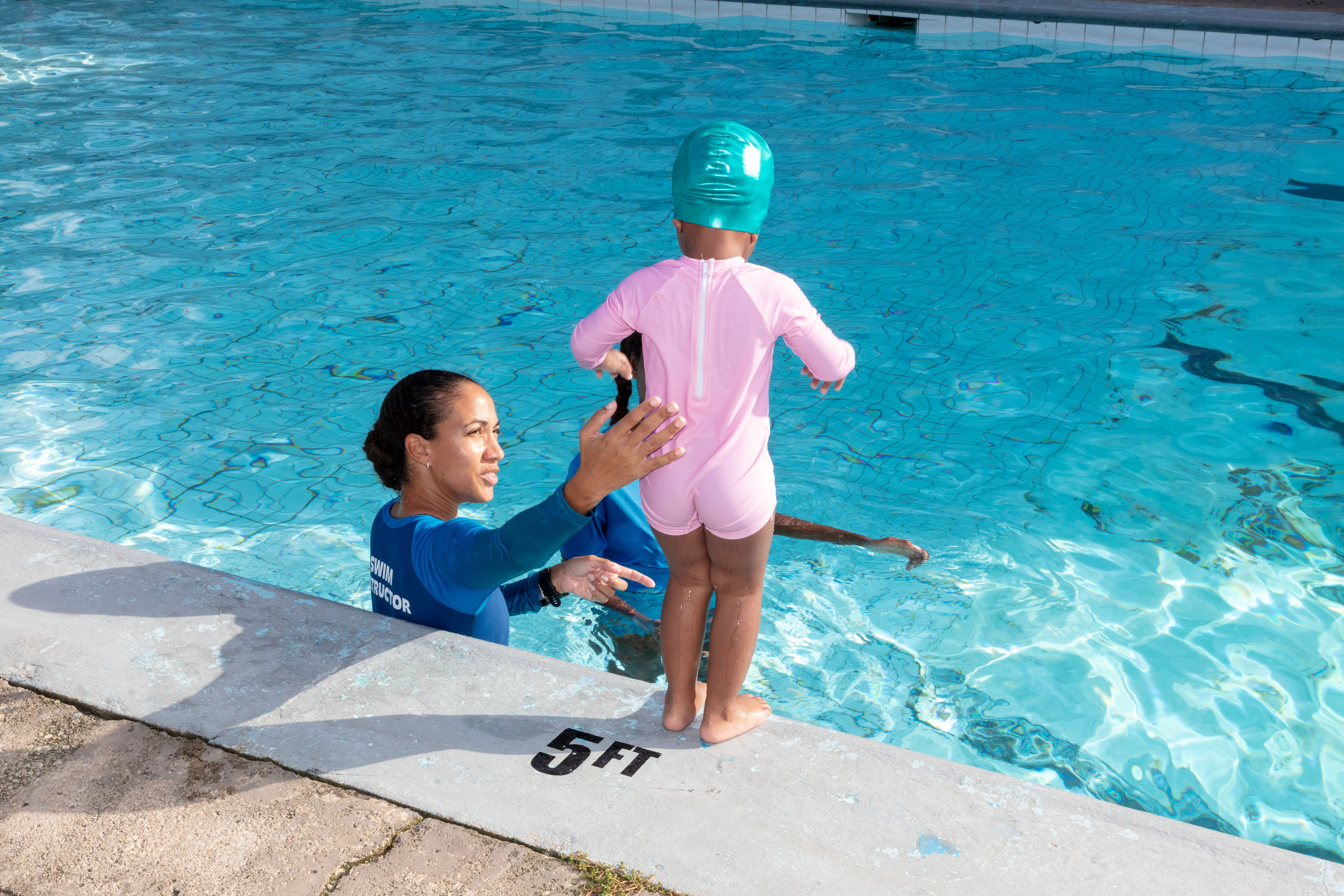 Coach supporting a young swimmer in the pool